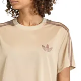 Remera Adidas color beige con cuello redondo, manga corta y las tres tiras características de la marca en color marrón en los hombros. Incluye el logo del trébol de Adidas bordado en el pecho.