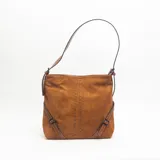 Cartera de hombro color marrón, confeccionada en gamuza, con detalle de tachas metálicas verticales en el centro y correas laterales decorativas con hebillas.