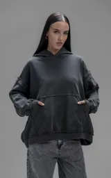 Hoodie oversize de algodón con efecto desgastado, costuras expuestas y roturas decorativas. Presenta capucha, bolsillo frontal tipo canguro y terminaciones deshilachadas.