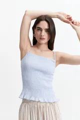Musculosa celeste con textura, de tiras finas y volados en el ruedo.