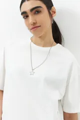 Remera blanca de algodón con cordones ajustables a los laterales, manga corta y cuello redondo.