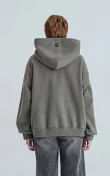 Hoodie de calce oversize y corte crop, confeccionado en frisa gamuzada de algodón. Presenta capucha forrada y bolsillo canguro frontal.