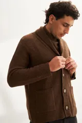 Cardigan marrón tejido con cuello smoking, cierre con botón y bolsillos delanteros.