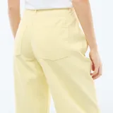 Pantalón de corte globo en color amarillo pastel, con tiro alto, cierre frontal con botón y bolsillos laterales.