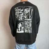 Buzo oversize de color negro con efecto lavado, manga larga y cuello redondo. Presenta un estampado gráfico en la espalda dividido en cuatro paneles con ilustraciones botánicas en color blanco.