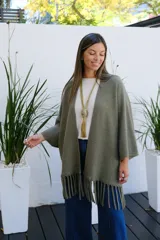 Saco abierto de tejido de punto en color verde oliva, con mangas tres cuartos y detalle de flecos en el ruedo.