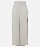 Pantalón largo tipo palazzo de color beige, confeccionado en mezcla de viscosa y lino. Presenta tiro alto, cintura elastizada en la parte posterior y aberturas frontales en las piernas con ribetes en tono marrón contrastante.