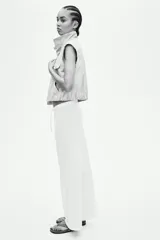 Pantalón de punto color blanco, de corte amplio y relajado, con cintura elástica y cordón ajustable.