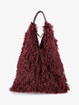 Cartera de diseño amplio y estructura flexible, confeccionada en textura de pelo sintético que aporta volumen. Cuenta con asas cortas integradas para llevar al hombro o en la mano.