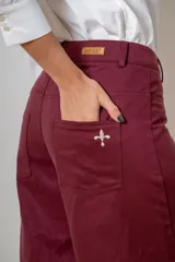 Pantalon de corte wide leg en color bordó, con cintura alta, cierre frontal con botón y bolsillos laterales.