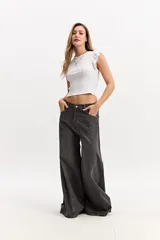 Pantalón jean súper oxford de tiro medio, color gris oscuro con efecto gastado, ajustado en la parte superior y con una apertura extra amplia hacia el ruedo.