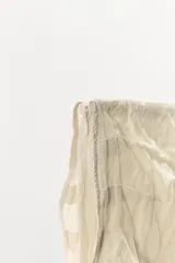 Falda midi de tiro bajo confeccionada en mezcla de viscosa con tejido efecto arrugado. Presenta una cintura con tejido en superposición combinado a tono y una abertura lateral en el bajo.