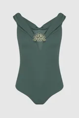 Body Patbo de color blanco, confeccionado en tejido texturizado con escote off-shoulder y abertura en V en el centro del pecho. Presenta detalles de apliques florales metálicos y pedrería en el escote y en la cintura drapeada.