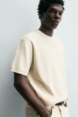 Camiseta de punto de algodón con textura perlada, corte regular fit, cuello redondo y manga corta con terminaciones en rib.