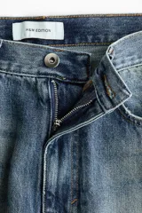 Jean de corte recto y tiro regular, confeccionado en denim de algodón en tono azul medio con efecto desteñido y diseño de cinco bolsillos.