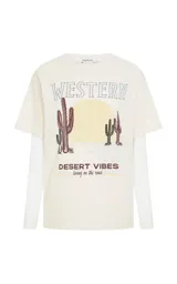 Remera de algodón color crudo con cuello redondo y mangas cortas, que incorpora mangas largas de tul ajustadas por debajo. Presenta un estampado frontal con temática western que incluye cactus y la frase Desert Vibes.