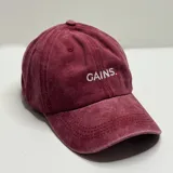 Gorro gris con visera y bordado frontal con la palabra "GAINS.".