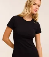 Vestido corto color ladrillo, confeccionado en tejido de punto rib de algodón y elastano. Tiene cuello redondo y mangas cortas.