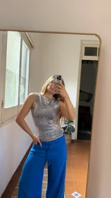 Top sin mangas de cuello redondo, confeccionado en tejido tipo jersey elastizado con acabado metalizado plateado.