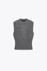 Chaleco de punto confeccionado en mezcla de lana color gris. Presenta cuello redondo, manga sisa con detalle de pliegues en los hombros y un bajo ancho en punto elástico que entalla la cintura.