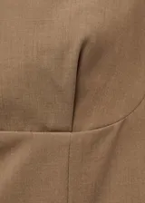 Chaleco de corte recto y diseño minimalista, con escote en pico profundo y tirantes anchos. Presenta un estilo sastrero sin mangas, ideal para combinar en conjuntos formales.