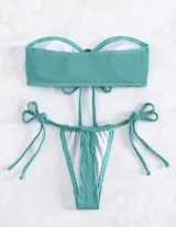 Conjunto de bikini turquesa acanalado, compuesto por un corpiño strapless con lazo central y una bombacha con tiras laterales ajustables.