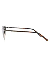 Lentes de sol estilo clubmaster con marco superior de acetato en estampado carey y puente y aros inferiores metálicos en tono dorado. Posee cristales polarizados color marrón con protección UV.
