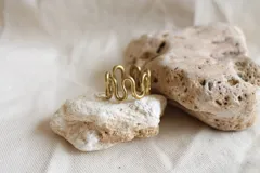 Anillo de bronce dorado con diseño de ondas.