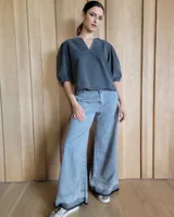 Pantalón de jean celeste de corte ancho con ruedo desflecado.