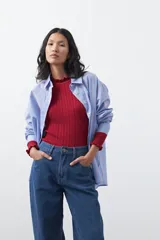 Jean de corte barrel con silueta curva y volumen controlado, de tiro medio y color negro. Presenta un diseño que se ensancha en la pierna y se ajusta levemente en el bajo, con cierre frontal y bolsillos laterales.