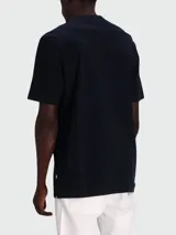 Remera de corte regular, color negro, con cuello redondo y detalle de monograma metálico en el pecho.