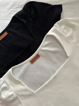 Remera de morley negra con escote recto y mangas cortas abullonadas.