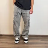 Jean cargo de corte recto y tiro medio, confeccionado en denim de algodón en tono azul claro. Presenta bolsillos laterales tipo cargo con solapa y costuras reforzadas.