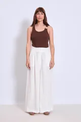 Pantalón palazzo de lino color crudo, con cintura alta y pinzas delanteras.