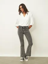 Jean de corte oxford en color negro, con tiro medio y ajuste en la cintura y caderas, ensanchándose desde la rodilla hacia el ruedo.