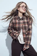 Campera corta de paño con estampado de cuadros en tonos marrones y beige, cuello clásico, cierre frontal con botones y bolsillos delanteros.