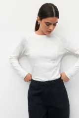 Remera gris de manga larga, corte ajustado y cuello redondo.