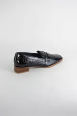 Mocasín clásico de cuero con textura croco acharolada, con taco cuadrado bajo símil madera.