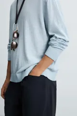 Jersey de algodón de corte relajado, color celeste claro con efecto lavado, cuello redondo y manga larga.