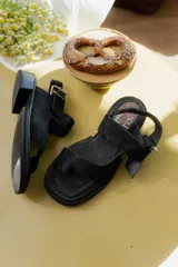 Sandalias de cuero marrón con diseño de punta abierta, tiras ajustables con hebilla metálica y suela de bloque bajo.