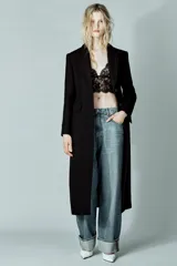 Abrigo largo entallado de Zara, confeccionado en mezcla de lana, con cuello solapa, manga larga, cierre frontal con botones, bolsillos con solapa y abertura en la espalda.