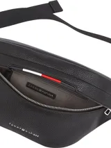 Riñonera negra de poliuretano granulado con cierre de cremallera, correa ajustable de textil trenzado con cierre de apertura fácil, bolsillo interior con cremallera, cinta distintiva y logo metálico de Tommy Hilfiger en la parte delantera.