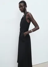 Vestido midi negro sin mangas, con cuello en V, cierre frontal con botones y cinturón ajustable del mismo tejido. Diseño evasé con mezcla de lyocell y lino.