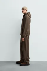 Pantalón jogger de corte regular fit y color negro, confeccionado en tejido compacto de algodón con interior de rizo. Cuenta con cintura elástica, bolsillos frontales y un bolsillo trasero de doble vivo.