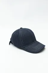 Gorra de jean azul con costuras visibles en contraste y visera curva.