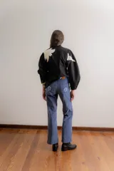 Pantalón de corte recto tipo jean, confeccionado en pana elastizada color azul grisáceo. Presenta bolsillos traseros con detalles bordados florales.