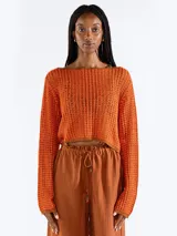 Sweater crop negro de punto abierto y manga larga con brillo sutil. Presenta escote bote y diseño relajado.