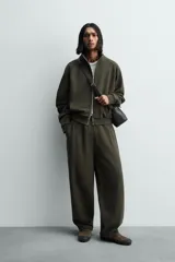 Sudadera de algodón con interior en rizo afelpado, cuello subido, manga larga y cierre frontal de cremallera. Presenta un efecto lavado que le da una apariencia única y bolsillos frontales ocultos en las costuras.