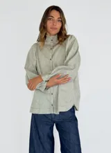 Camisa de lino color verde claro, con cuello mao, mangas largas abullonadas y cierre frontal con botones.