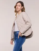 Campera matelaseada color verde militar con diseño capitoneado de rombos, escote redondo sin cuello y cierre frontal con broches a presión. Cuenta con bolsillos frontales oblicuos y ruedo curvo con aberturas laterales.
